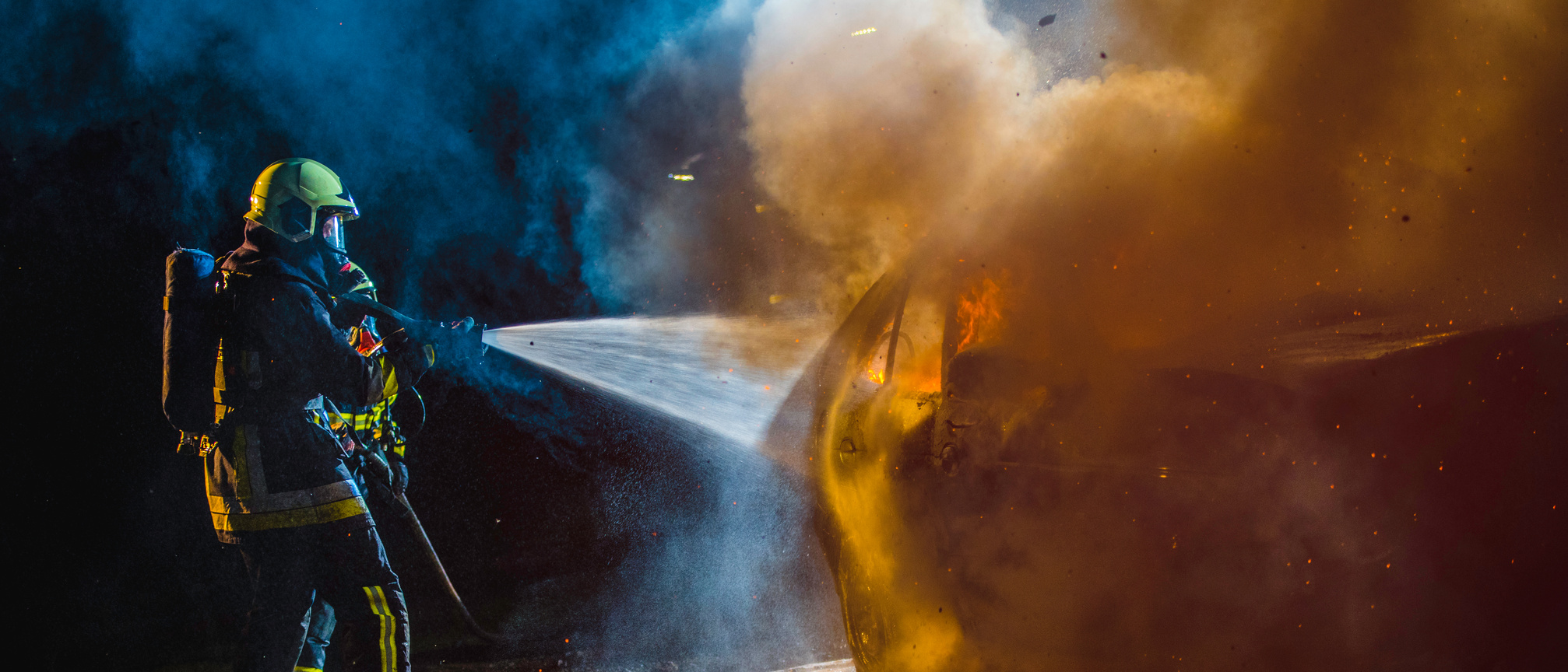Fireman extinguishing a burning car